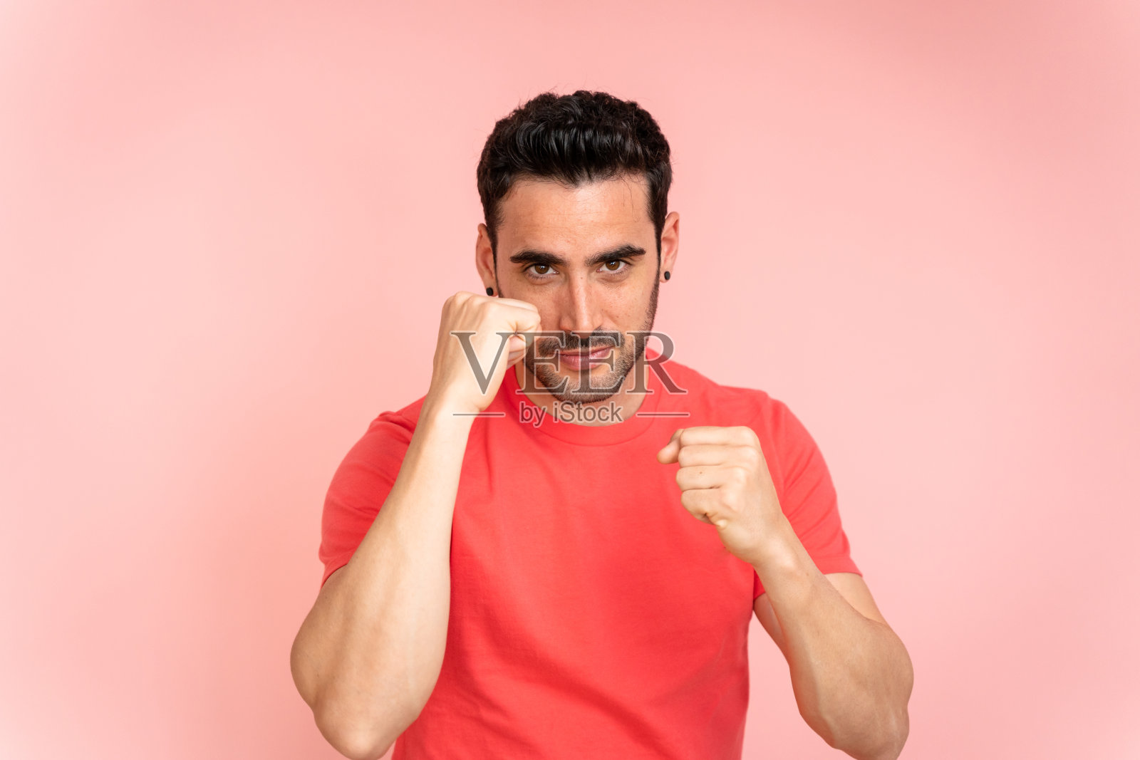 一名男子在摄影棚里展示拳头。照片摄影图片