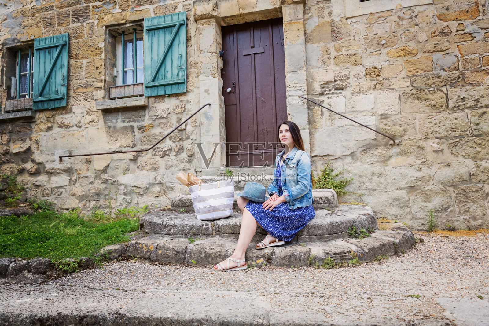 迷人的年轻女子坐在古老的法国城市户外的石头楼梯上摆姿势照片摄影图片
