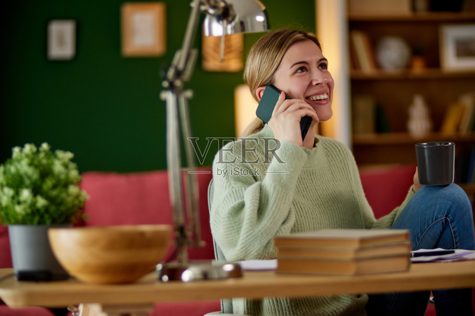 有魅力的年轻女子在家里办公室打电话照片摄影图片