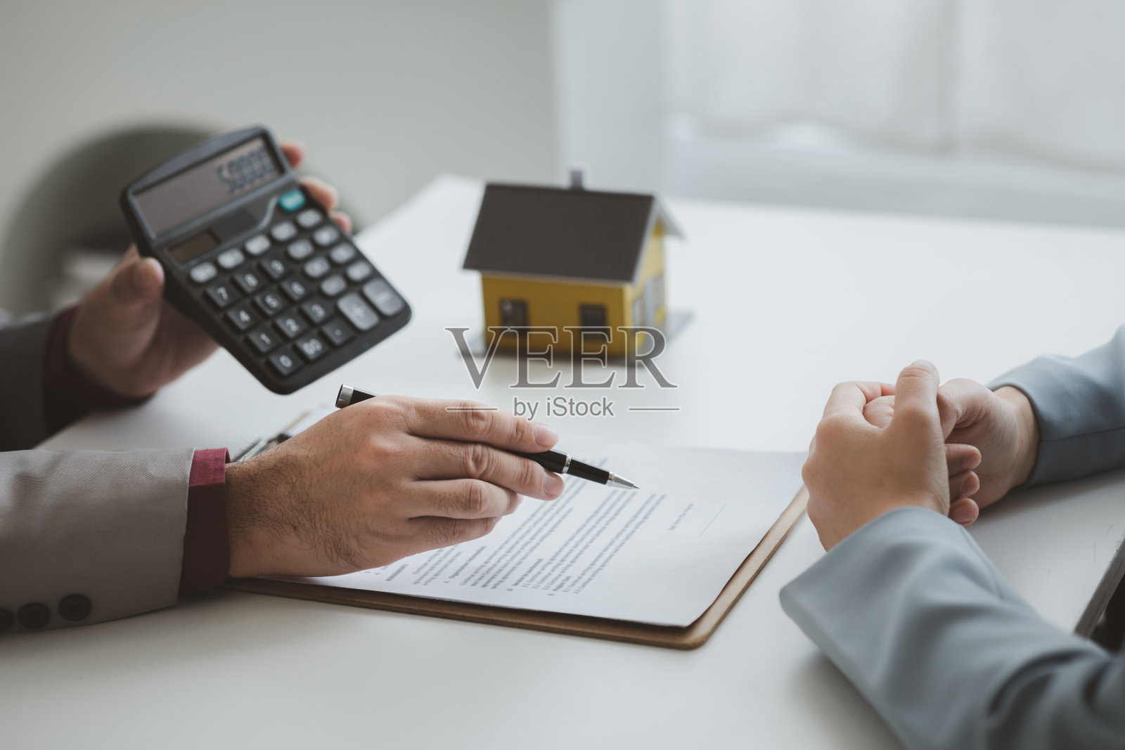 房地产经纪人向客户解释项目中房屋的模型，向客户解释和展示有关房屋和购买贷款的信息。房地产交易概念。照片摄影图片