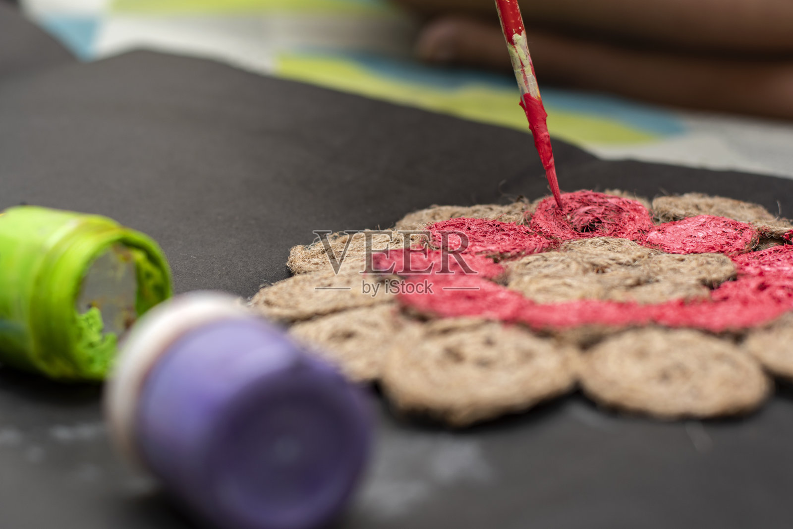 一位女艺术家用刷子在她的门垫上作画来装饰她的家照片摄影图片