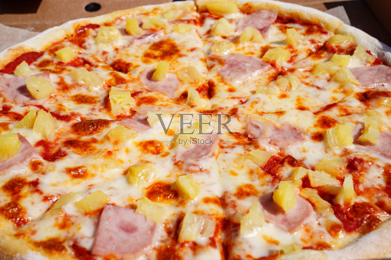 菠萝火腿披萨是一种很受欢迎的披萨，被称为夏威夷披萨。照片摄影图片