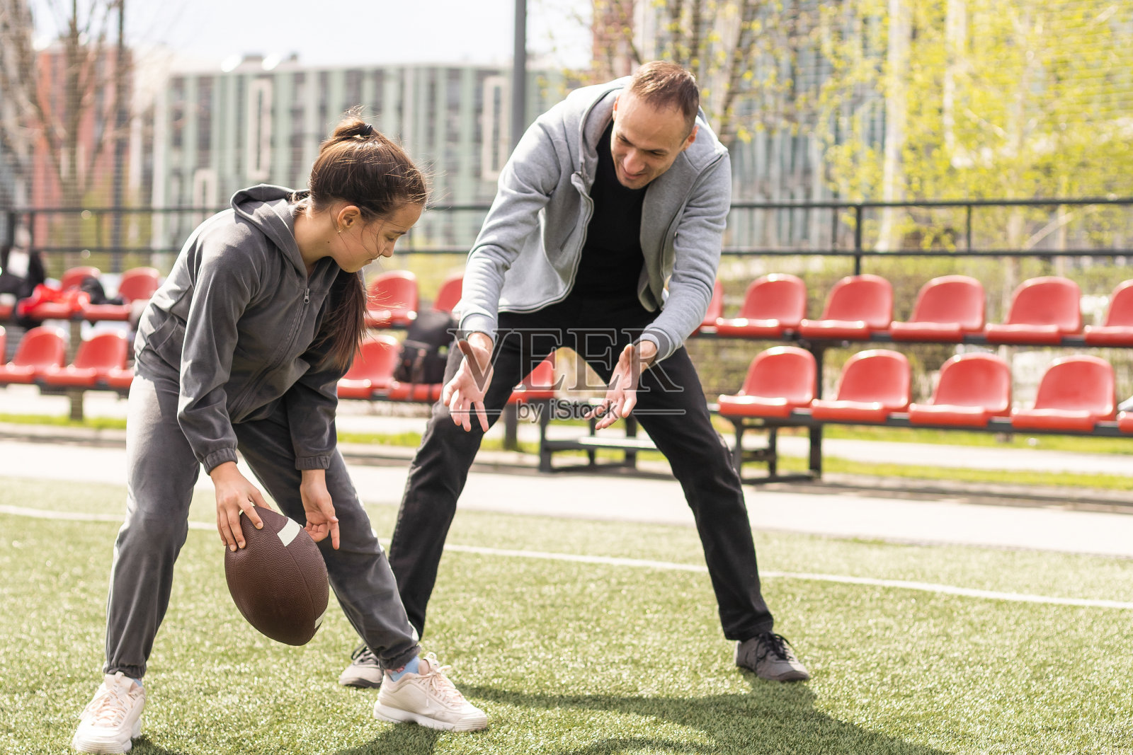 一家人在公园一起踢美式足球。照片摄影图片