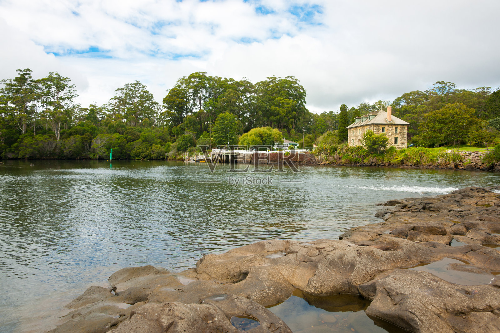 穿过海湾的岩石堤道到历史悠久的石头商店照片摄影图片