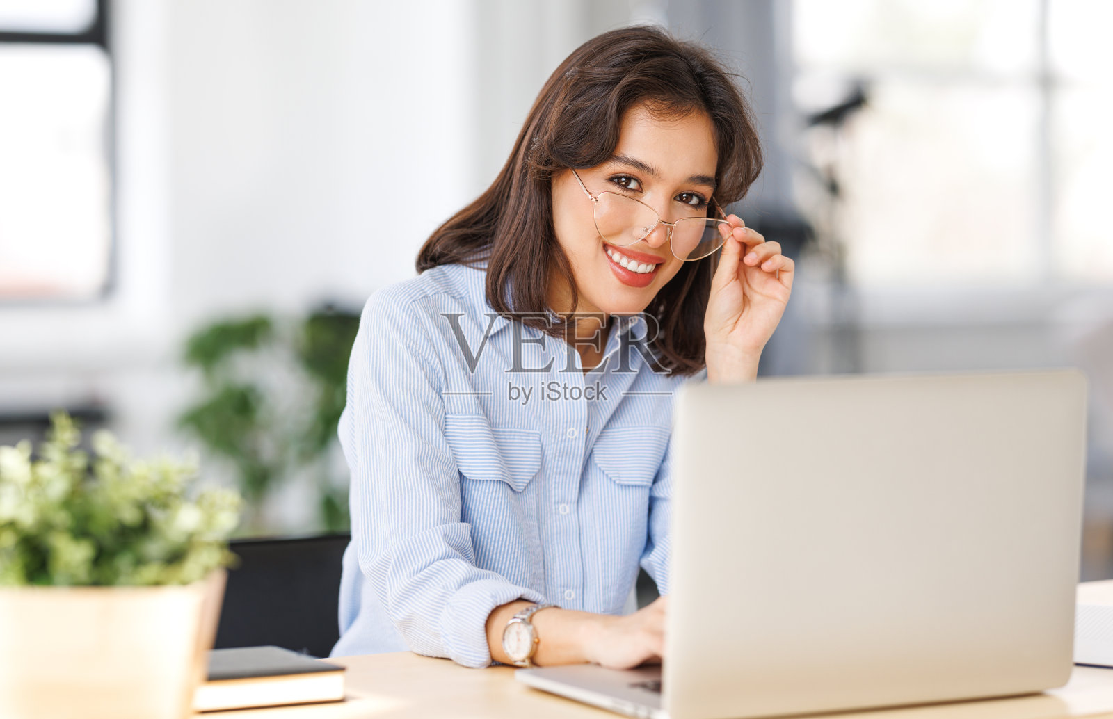 美丽的微笑女人在家里用笔记本电脑远程工作照片摄影图片