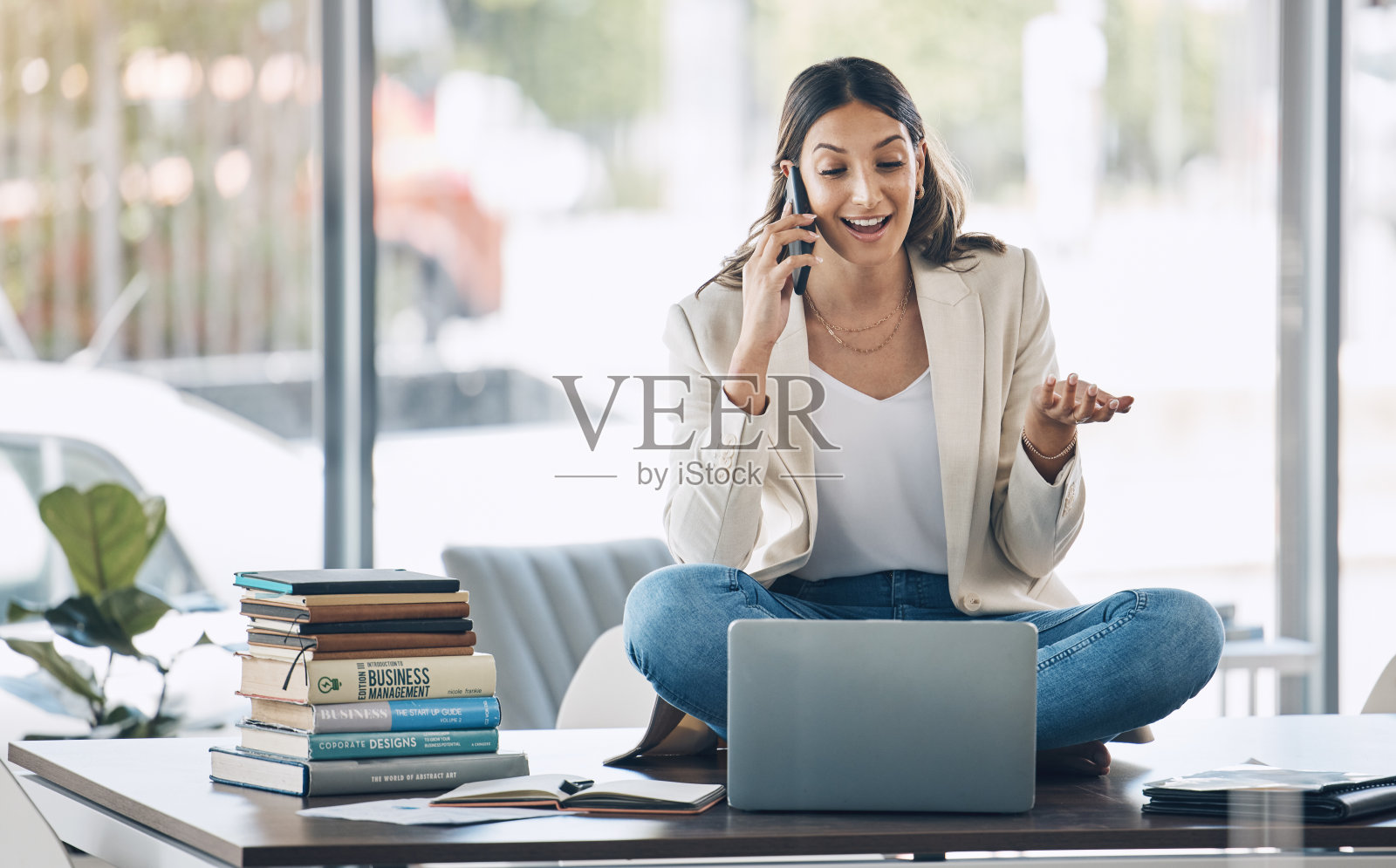 员工，笔记本电脑和电话，坐在桌子上放松创业公司，营销公司或广告公司。微笑，快乐和聊天的女人对移动通信技术，笔记本电脑或书籍学习照片摄影图片