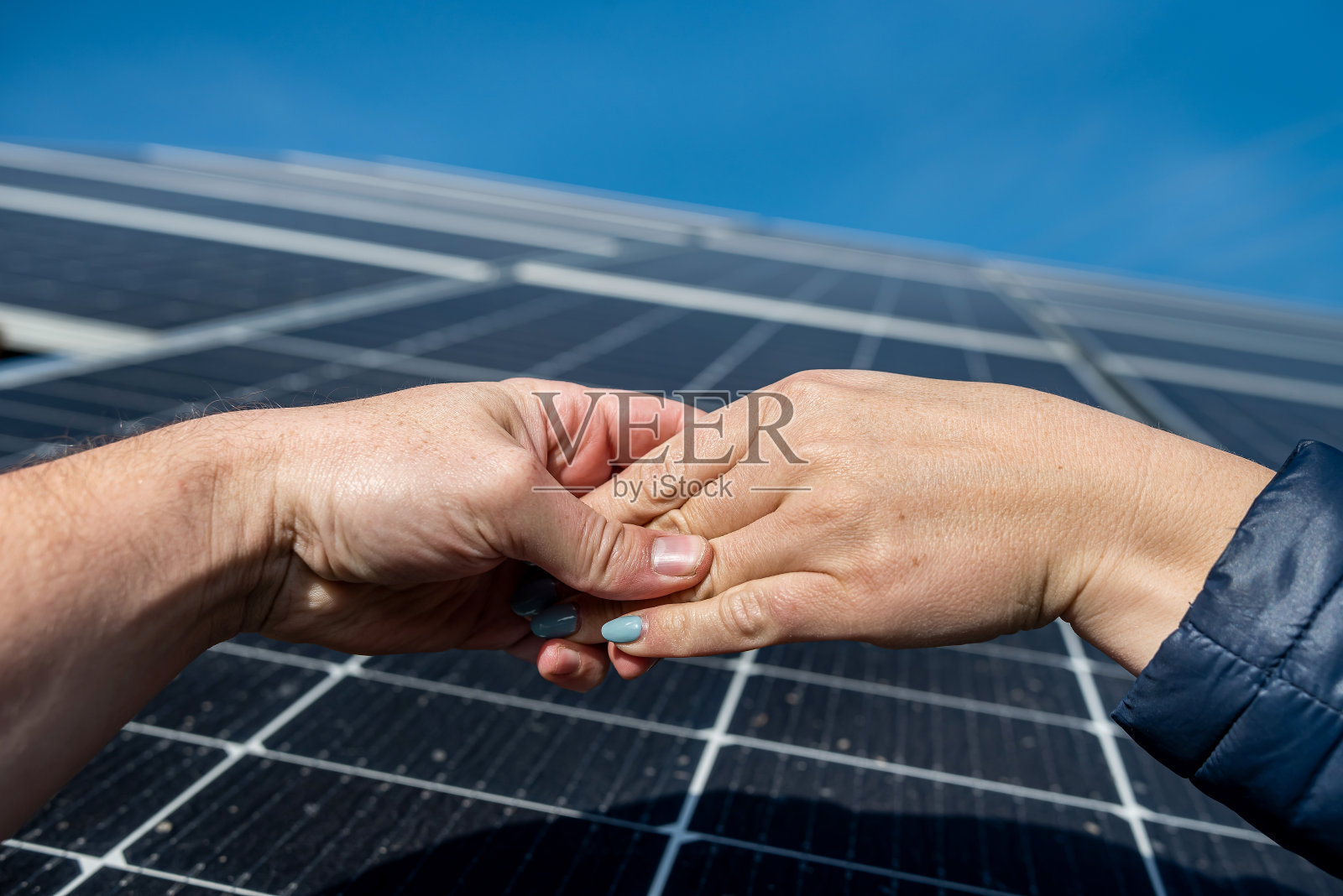 两对手在太阳能板的背景下成交后握手。照片摄影图片