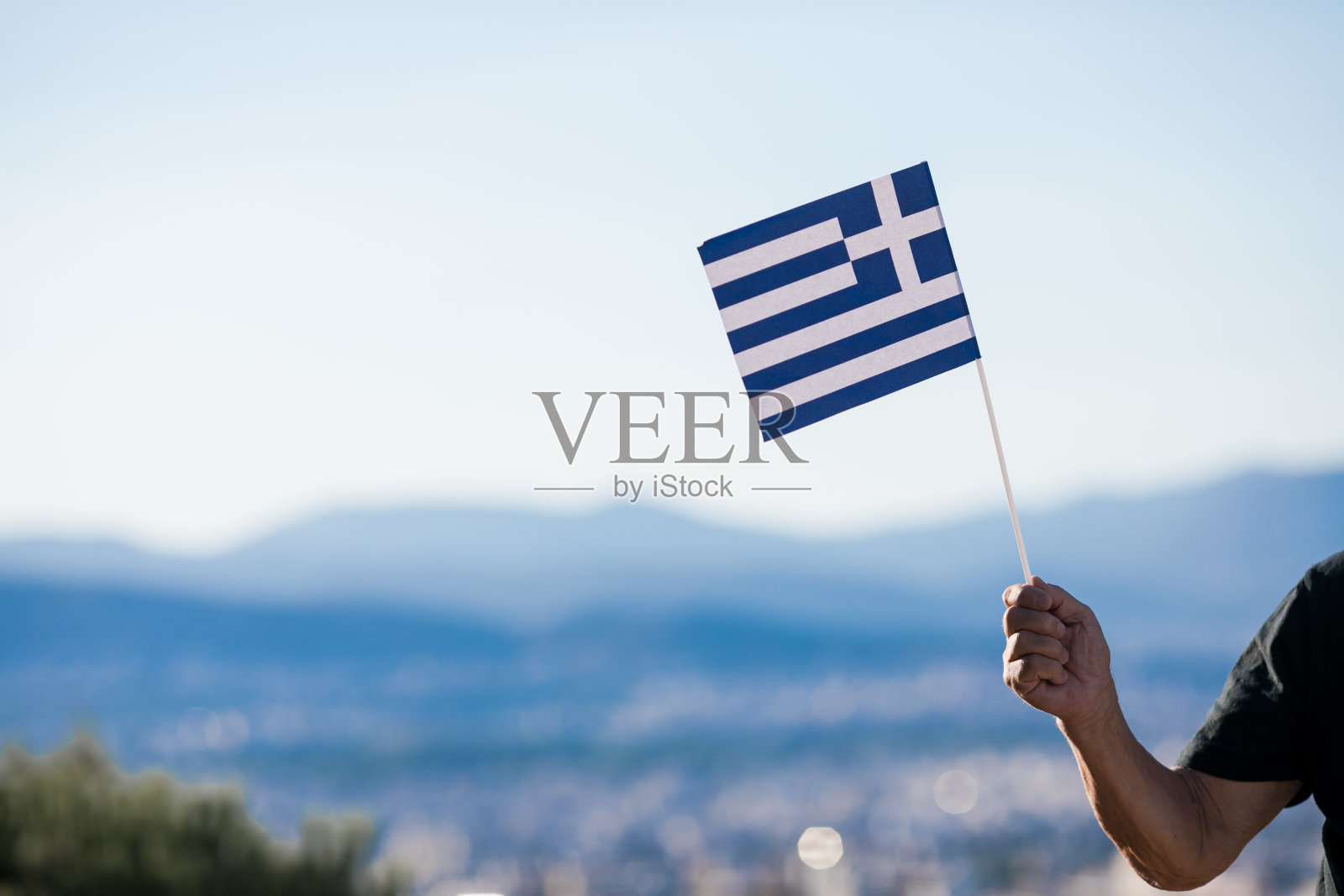 英俊的白发退休男子手持希腊国旗。希腊的国家象征照片摄影图片