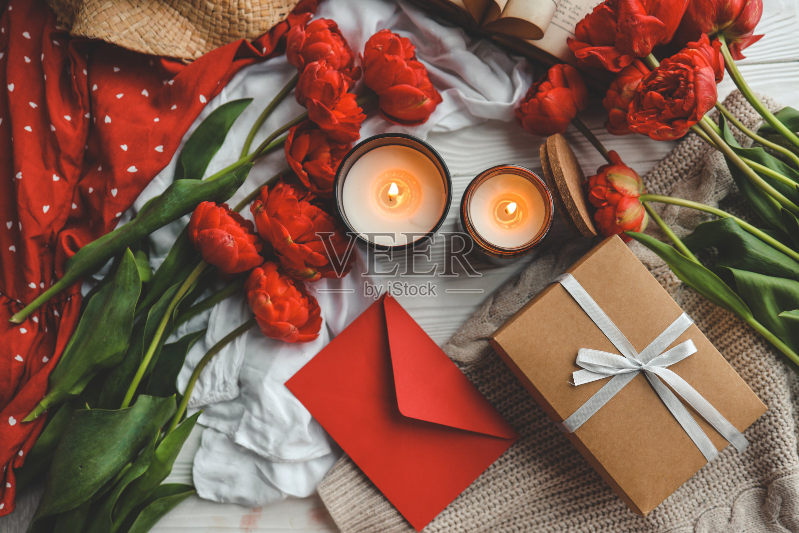 节日构图俯视图平铺。礼品盒、鲜花、信封、蜡烛照片摄影图片