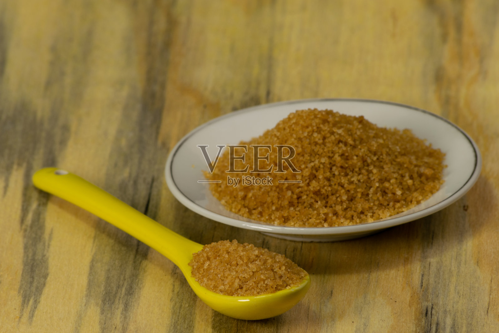 红糖放在小盘子里，旁边放一个勺子照片摄影图片