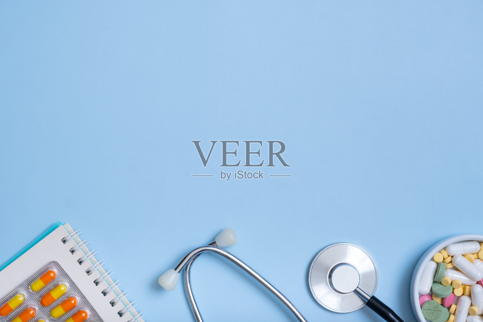 听诊器碎片，笔记，蓝色背景的药片，还有拷贝空间。医疗理念平铺，俯视图照片摄影图片