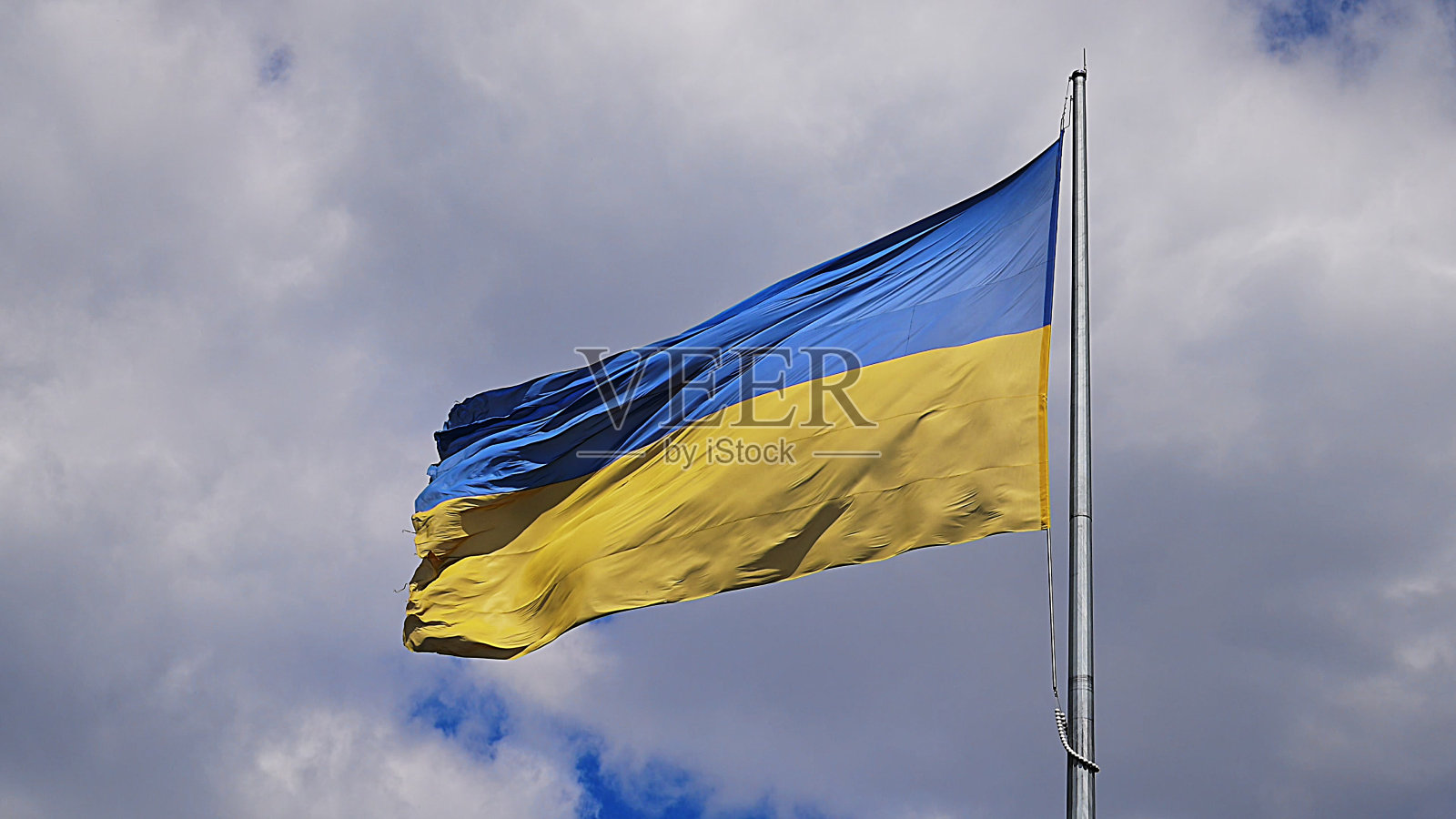 巨大的乌克兰国旗在蓝天上飘扬。照片摄影图片
