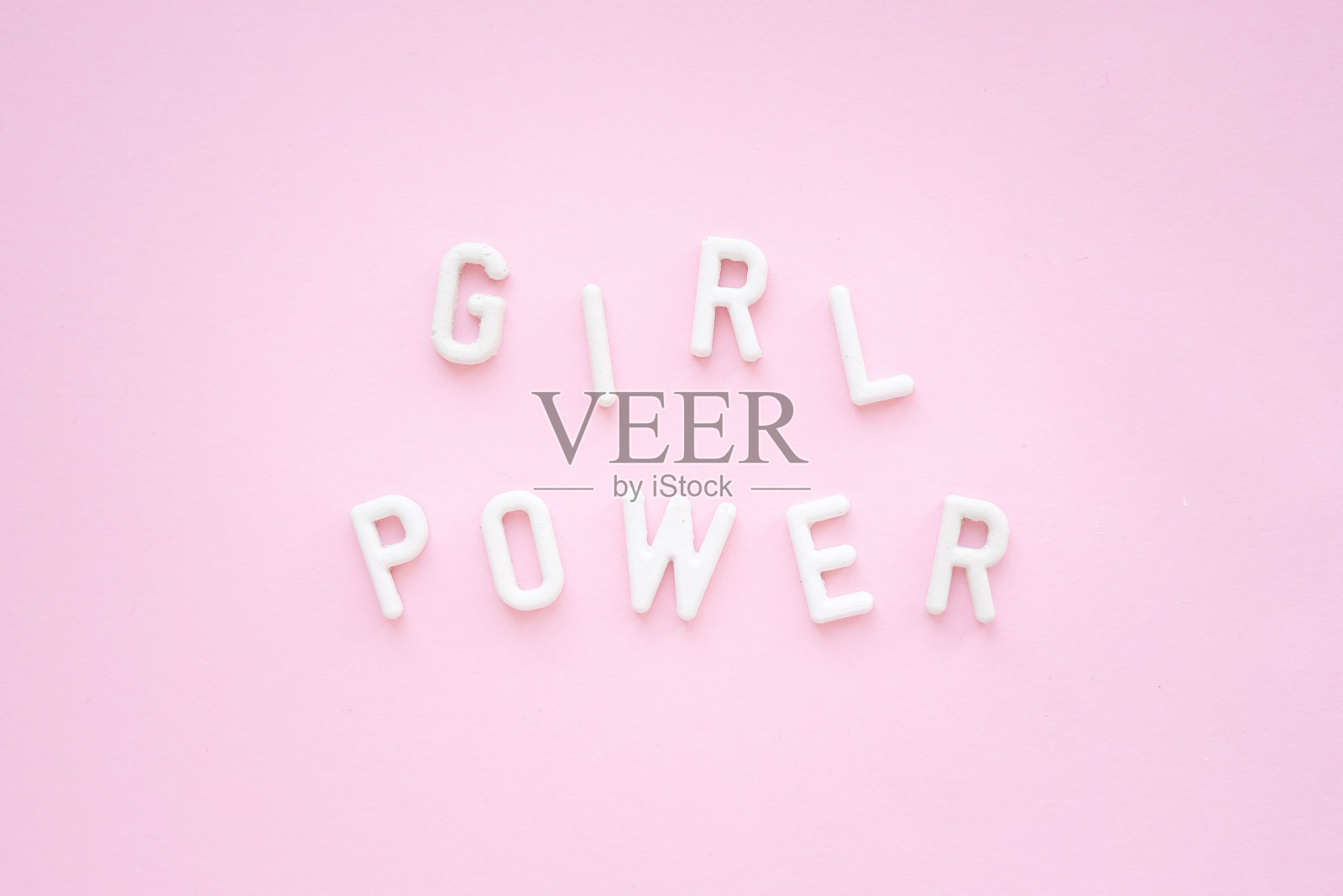 题词:粉色背景上的白色石膏字。女权主义的口号。照片摄影图片