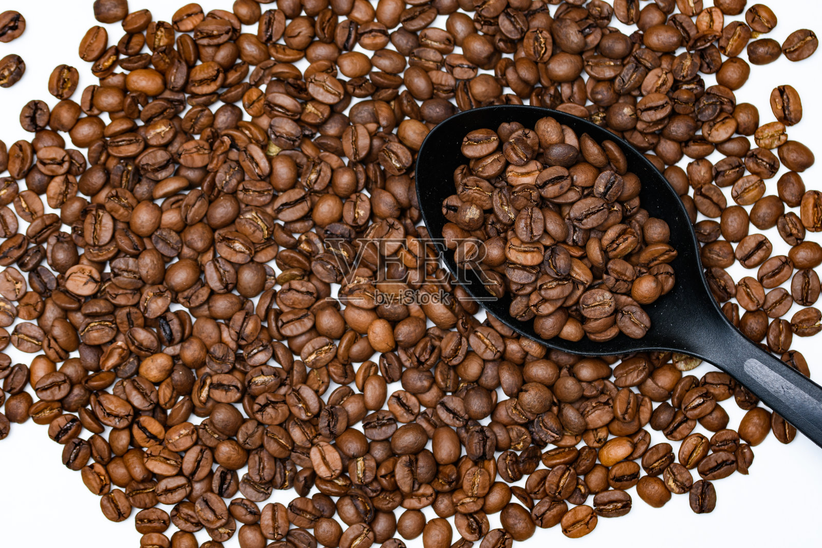 用厨房勺子烤过的咖啡豆散落在柜台上照片摄影图片