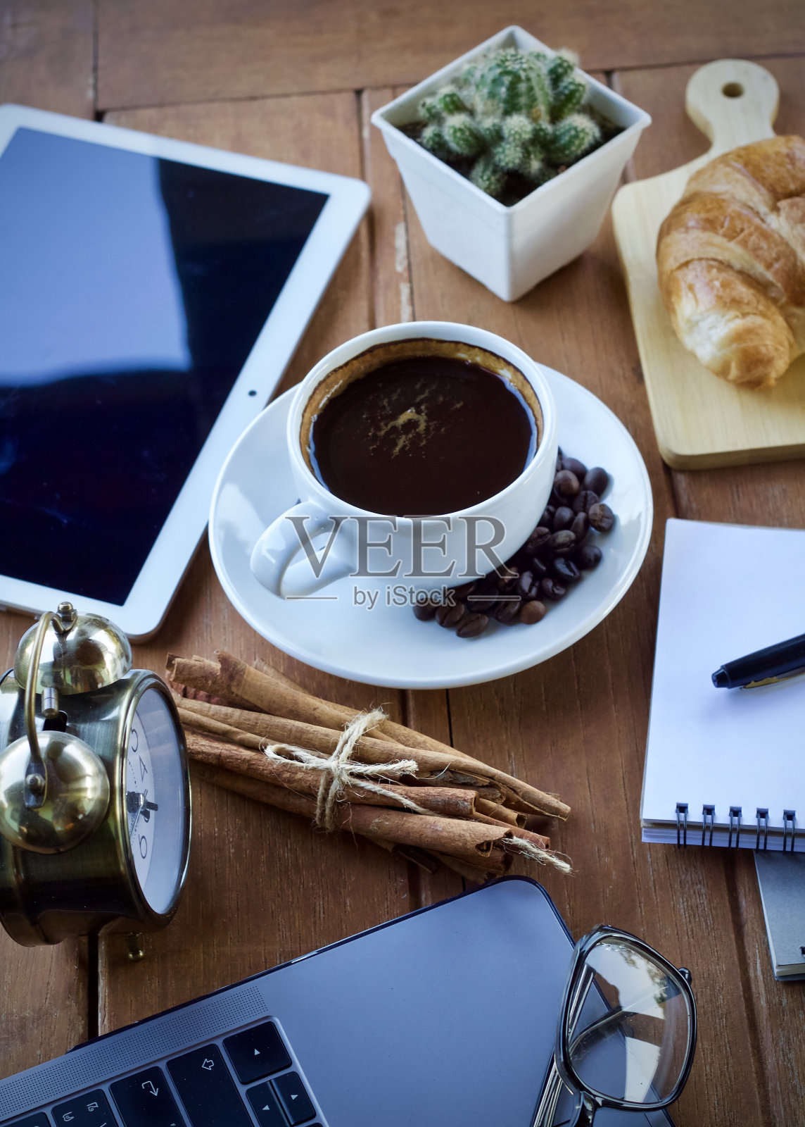 在一个美好的早晨，坐在办公桌上喝一杯热咖啡。照片摄影图片