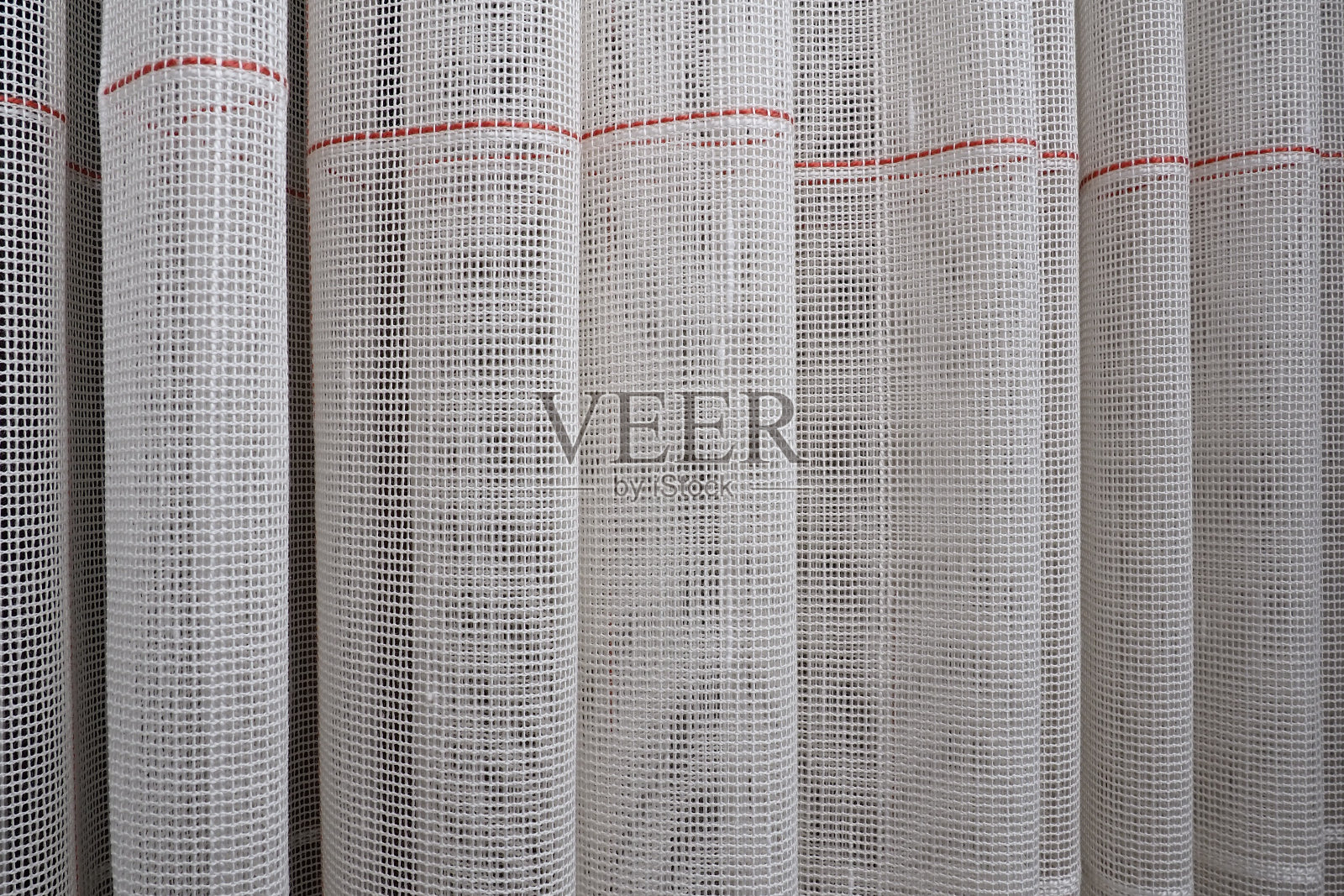 用细线编织而成的白色粗棉布或亚麻窗帘。简单紧凑经济的公寓内部。房间的窗户装饰。红色的条纹。照片摄影图片