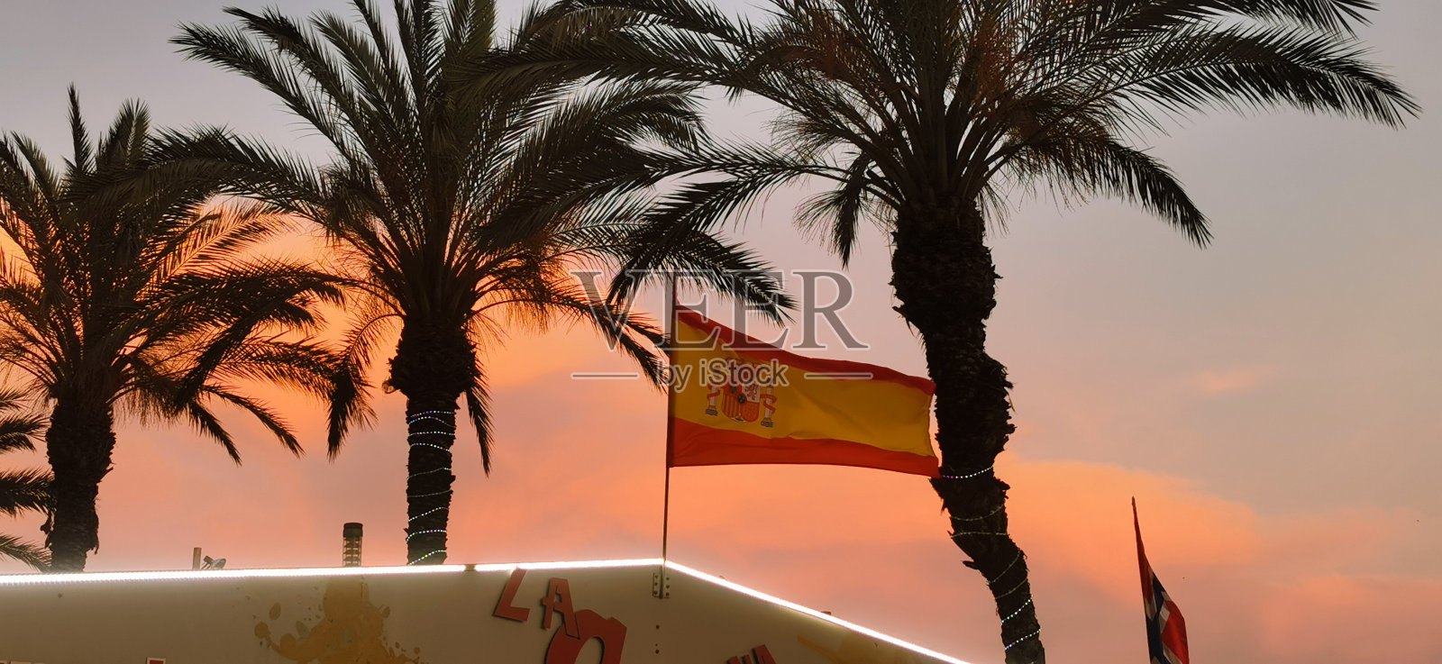 日落时屋顶上的西班牙国旗照片摄影图片