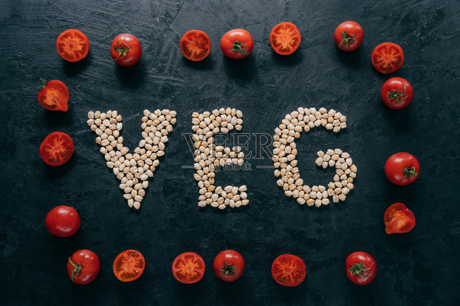 红色成熟的西红柿在框架和字母形状的鹰嘴豆在深色背景的俯视图。素食概念。有机螺母。维生素照片摄影图片