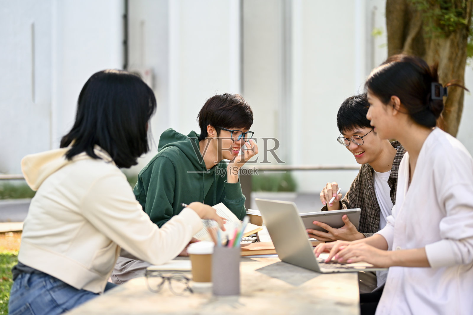 一群快乐的亚洲年轻大学生在讨论他们的学校项目照片摄影图片