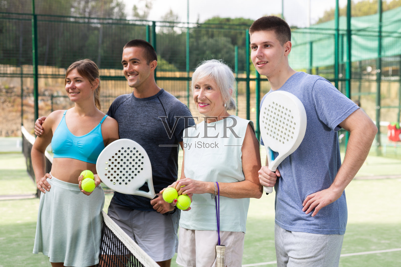 户外网球场上四个快乐的模型选手的肖像照片摄影图片
