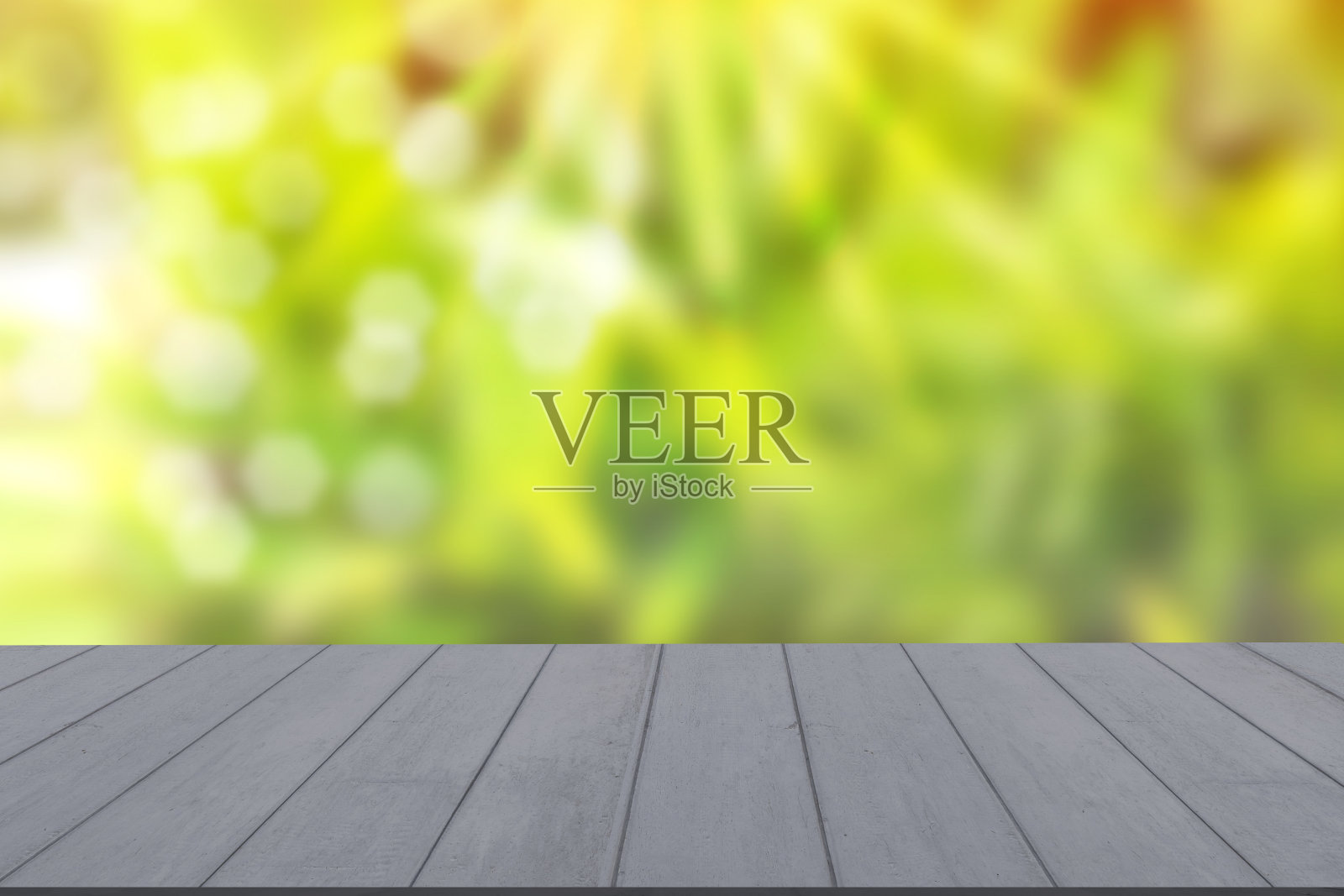 木质桌面以自然的绿色迷彩背景和各种树叶，清新明亮的阳光，产品空的概念。照片摄影图片