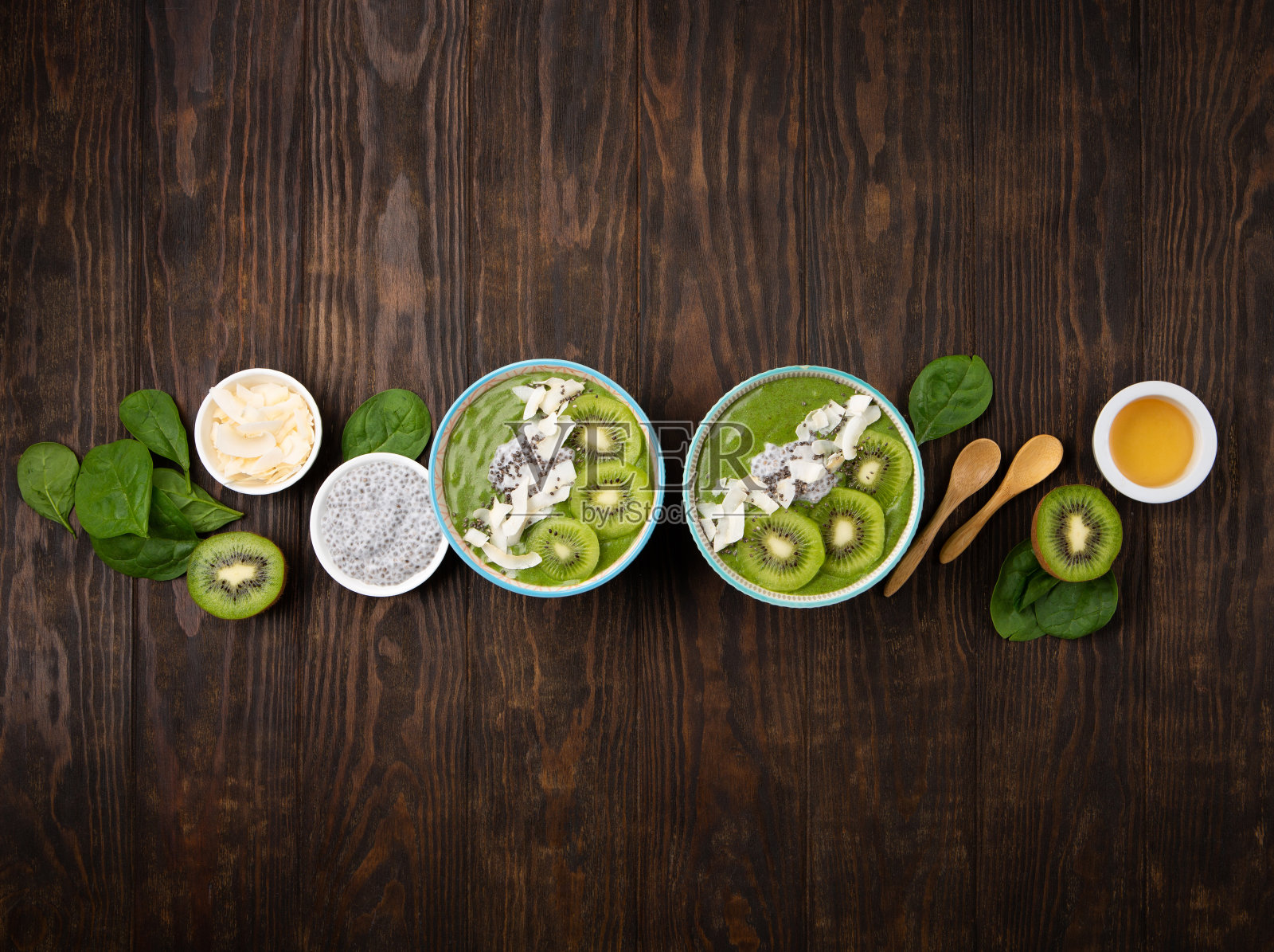 绿色奶昔碗与菠菜，香蕉，奇亚籽在棕色背景照片摄影图片