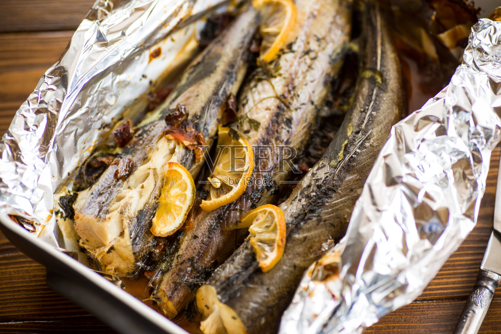 用锡箔纸蘸上调味料和香料的烤鱼照片摄影图片