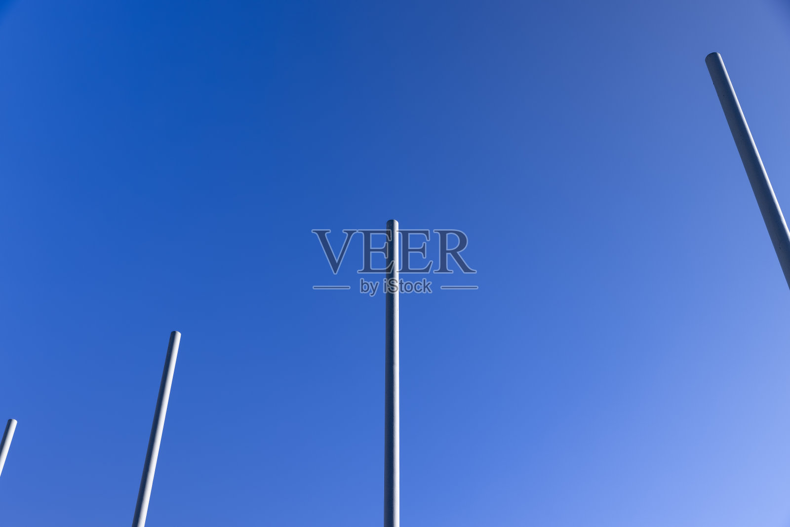 一组空的金属旗杆映衬着蓝天的背景照片摄影图片