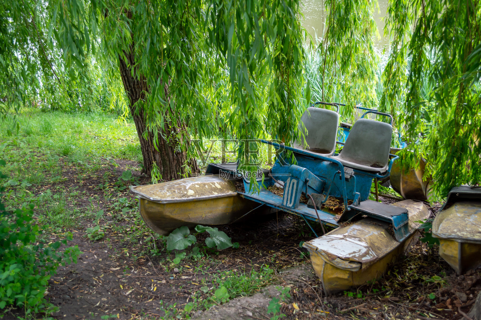 湖边有一艘废弃的旧双体船照片摄影图片
