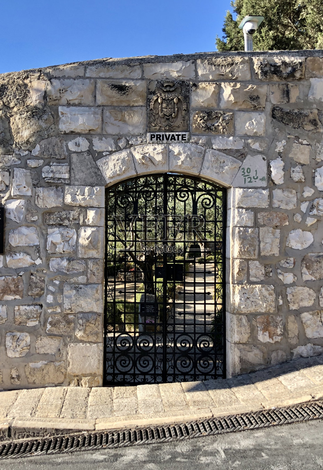 带有石头拱门和蓝天的锻铁大门照片摄影图片