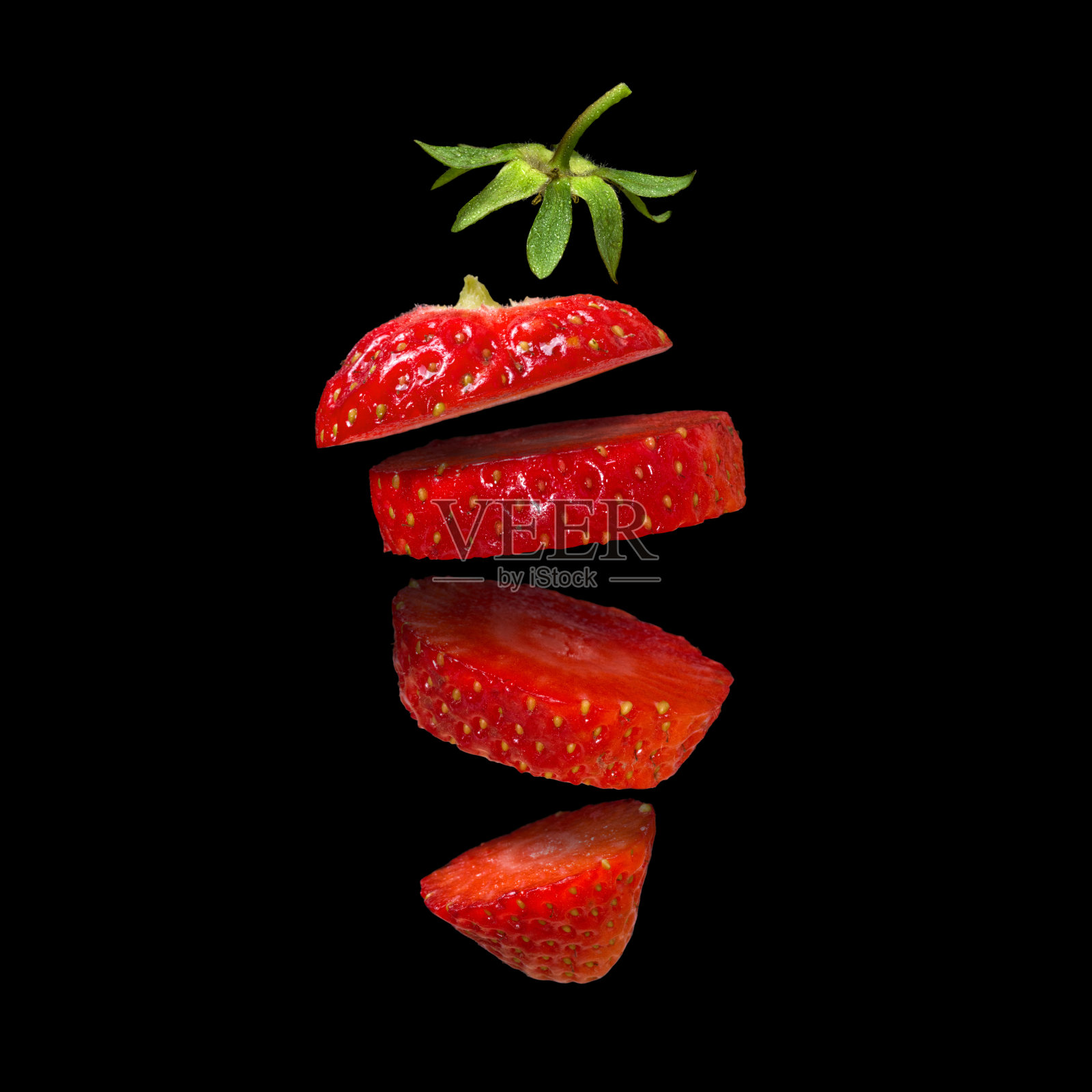 草莓片孤立在黑色背景。超现实主义的设计。一片片的水果漂浮在空中。照片摄影图片