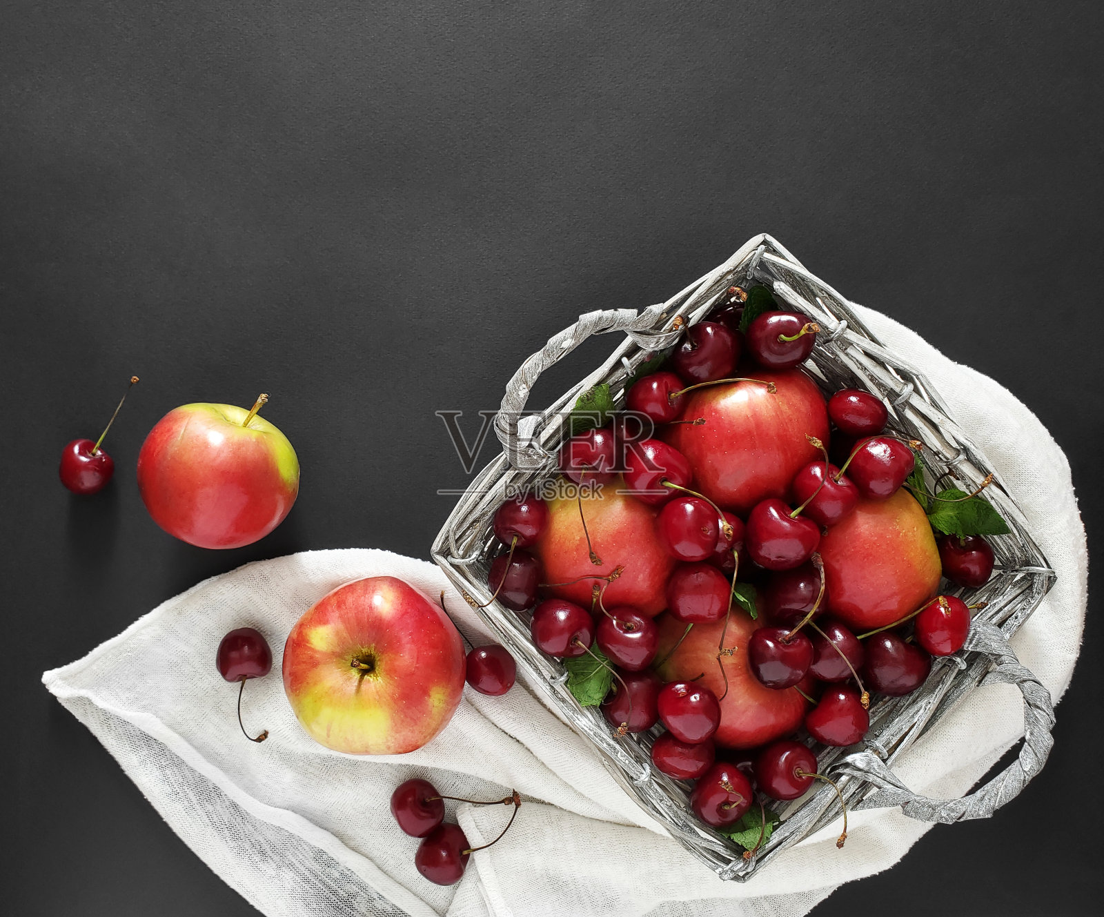 柳条篮子里的苹果和樱桃照片摄影图片
