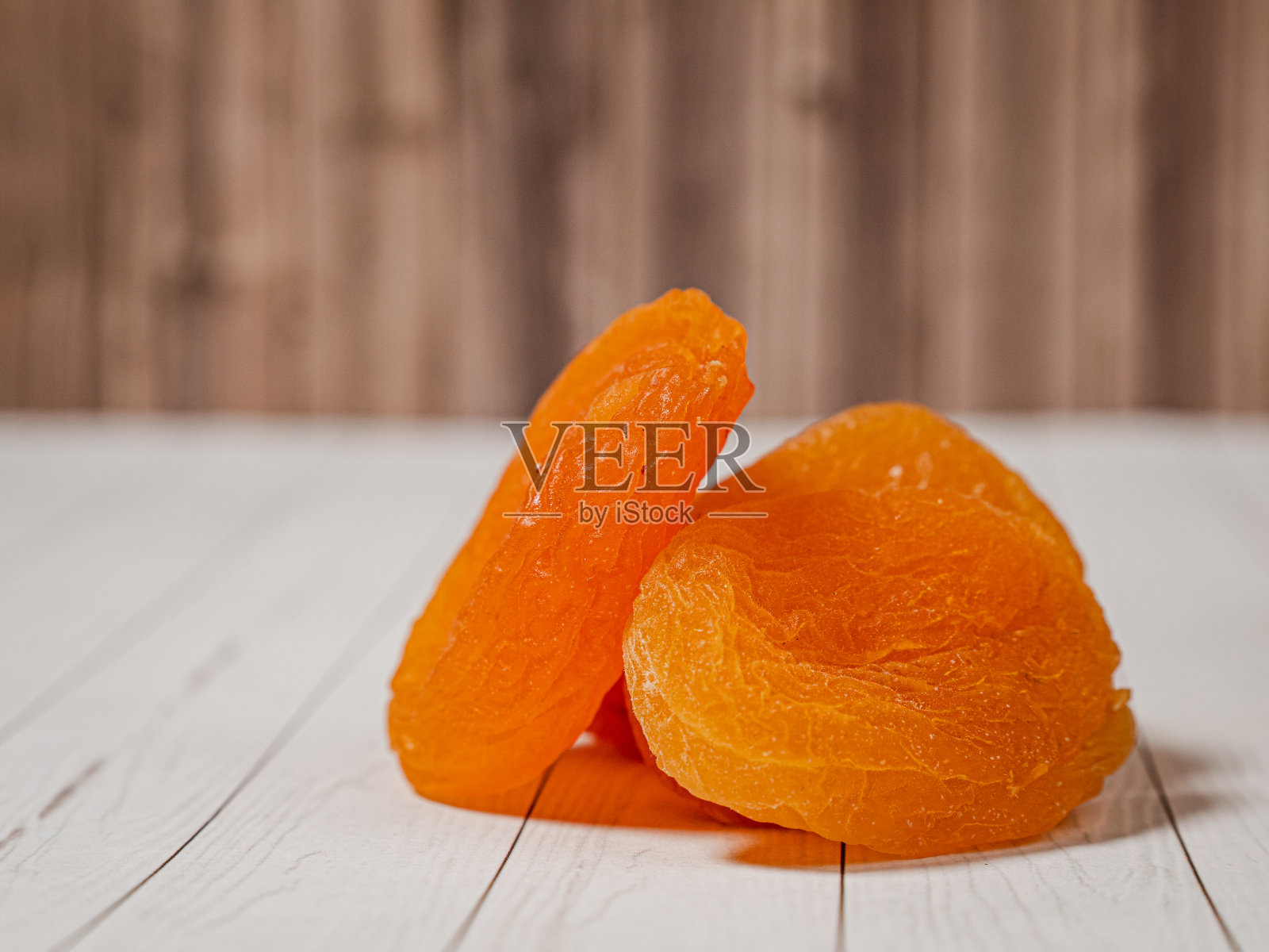 木质背景上的干杏木碗，选择性聚焦。照片摄影图片