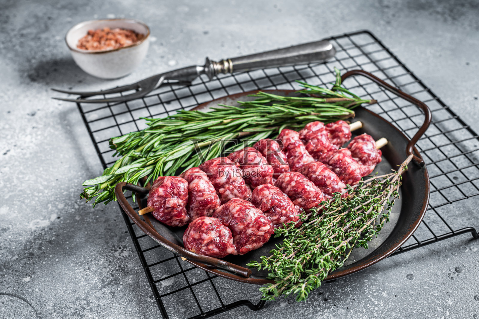 用香草、香料和肉叉装饰的土耳其乌尔法烤肉串。灰色的背景。俯视图照片摄影图片