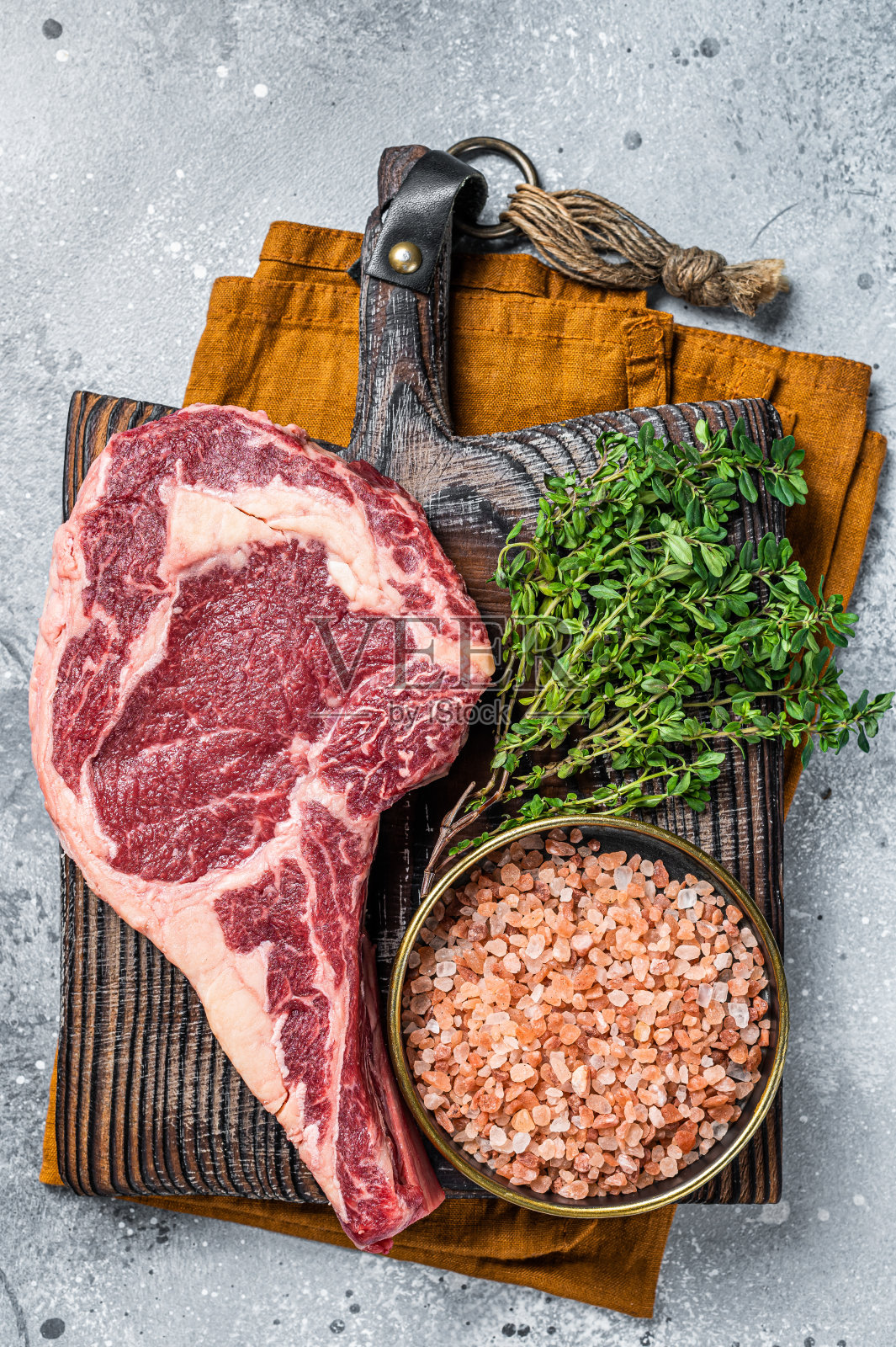 生的未煮的黑安格斯牛扒或肋眼牛排。灰色的背景。俯视图照片摄影图片