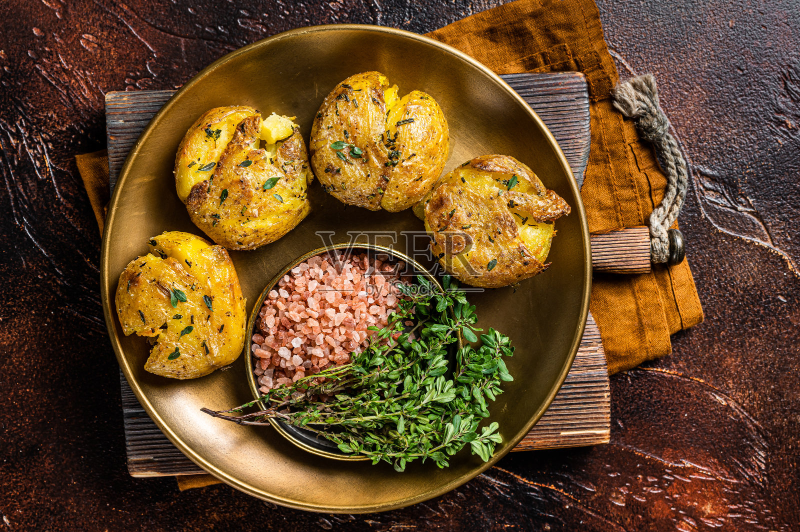 用迷迭香和百里香烤碎的土豆泥。黑暗的背景。俯视图照片摄影图片