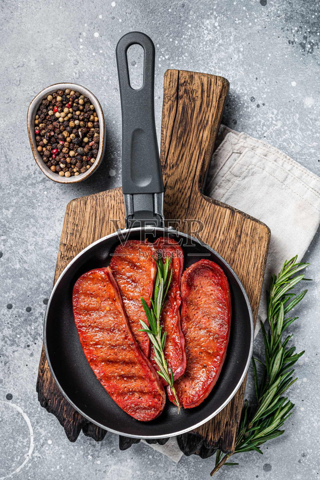 用煎锅烹调土耳其Sucuk牛肉肉肠。灰色的背景。俯视图照片摄影图片