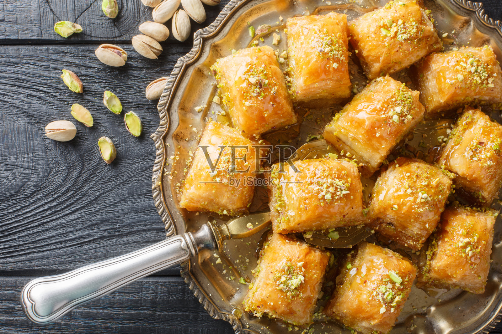 传统的土耳其甜点开心果果仁蜜蜜特写在一个盘子里。水平俯视图照片摄影图片