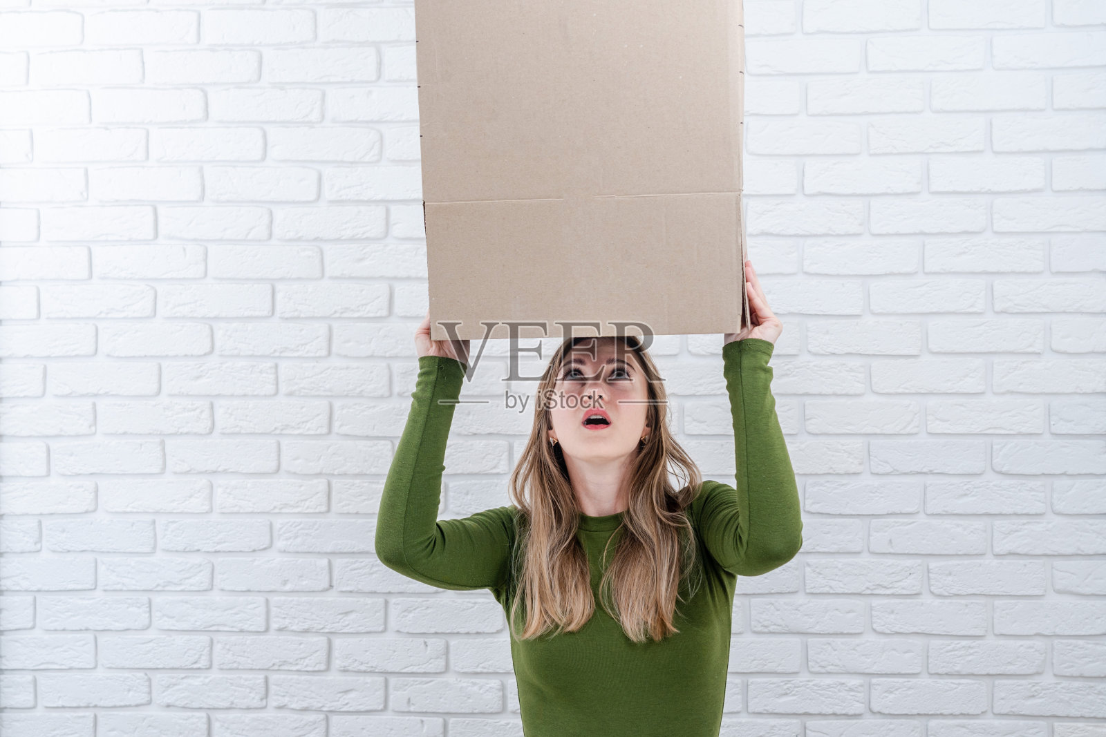 头上顶着个包裹盒的美女。投递包裹照片摄影图片