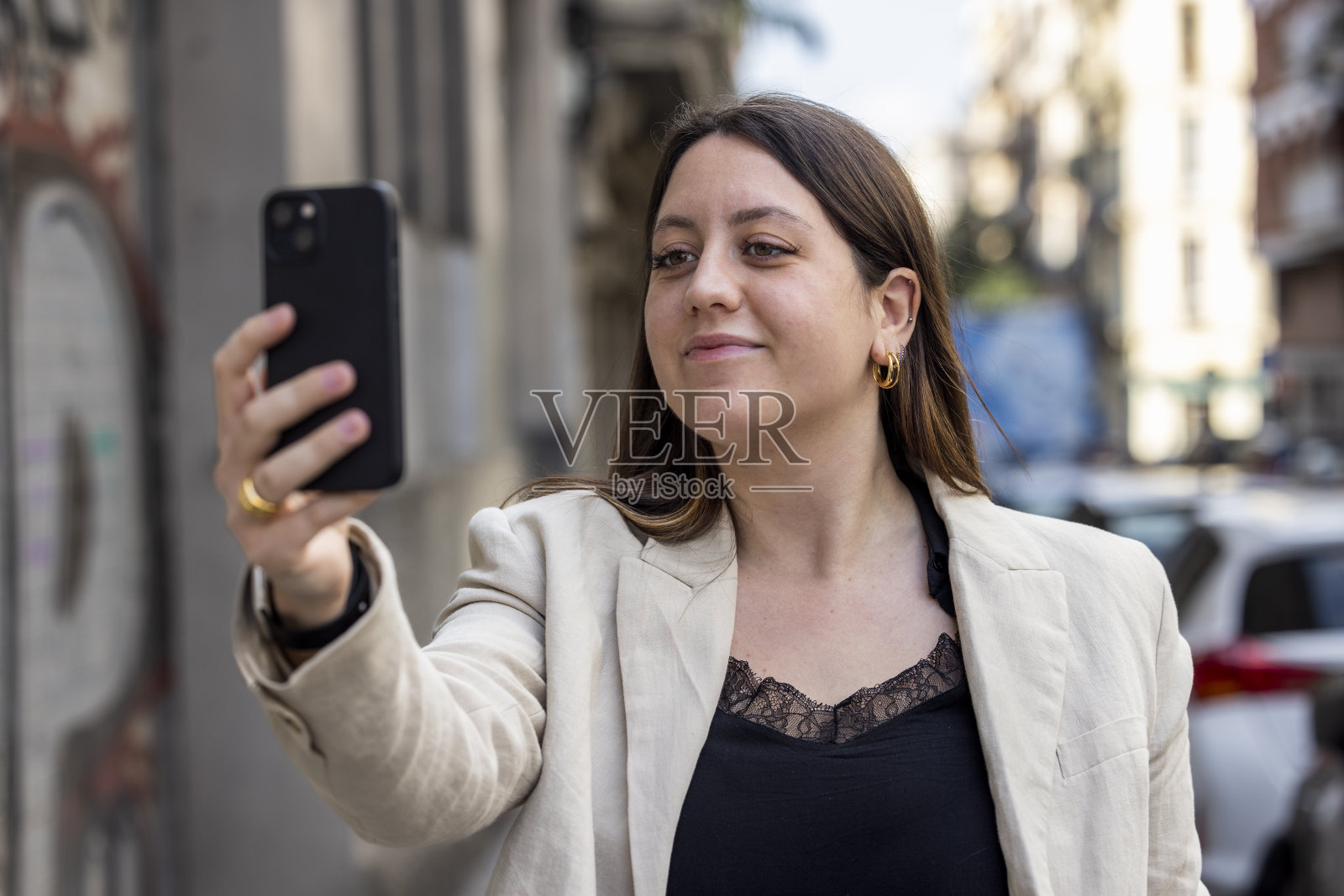 年轻女性，z世代，在巴塞罗那的城市环境中使用她的手机。照片摄影图片