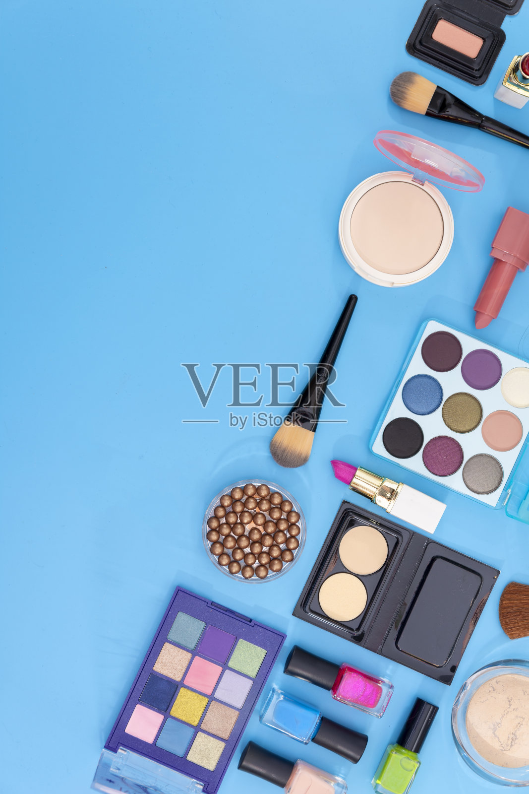 蓝色背景的装饰性化妆品和化妆刷。副本的空间。照片摄影图片
