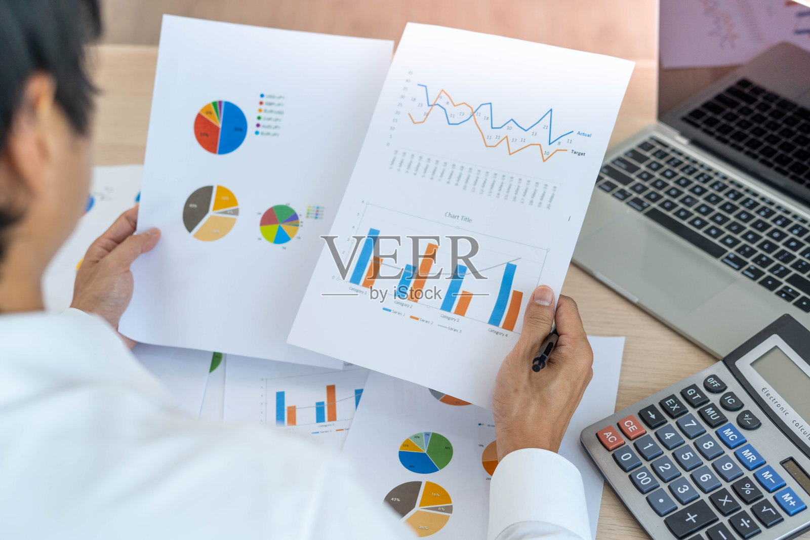 一个人用计算器从统计图表中计算公司利润。商人看图表，电子表格，银行账户，统计，经济，数据分析，股票交易照片摄影图片