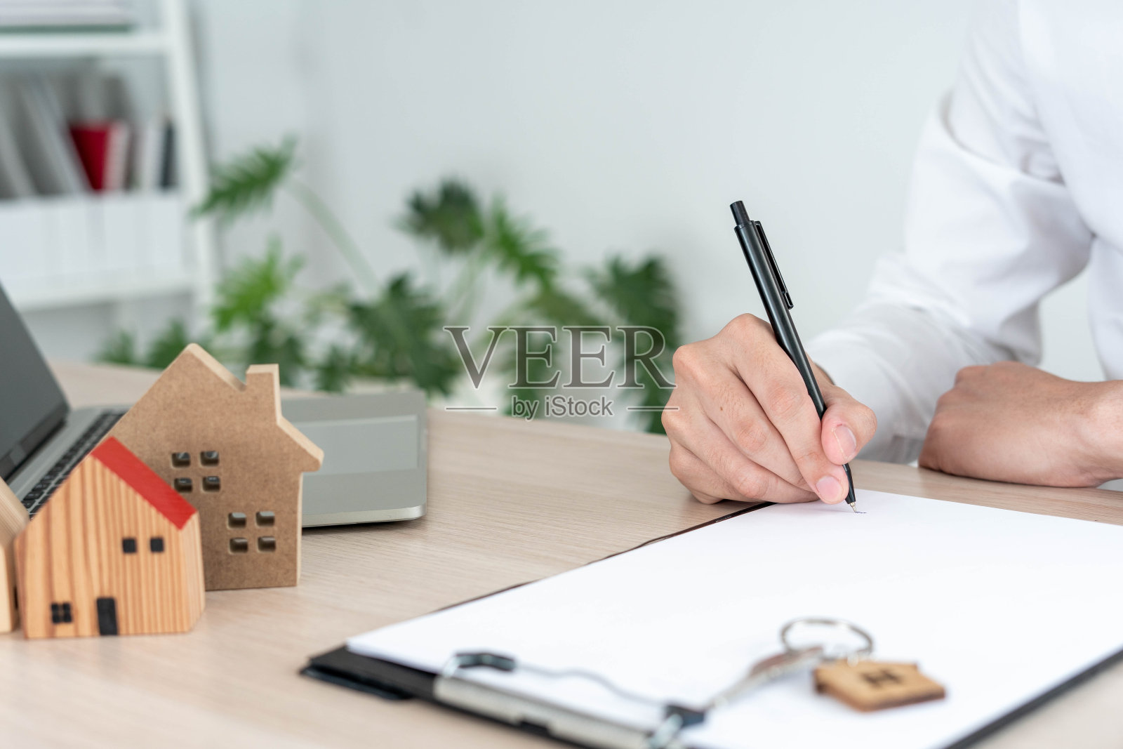 房屋买卖合同及保险租赁合同。房地产经纪人在把合同交给客户之前详细地写好合同。照片摄影图片
