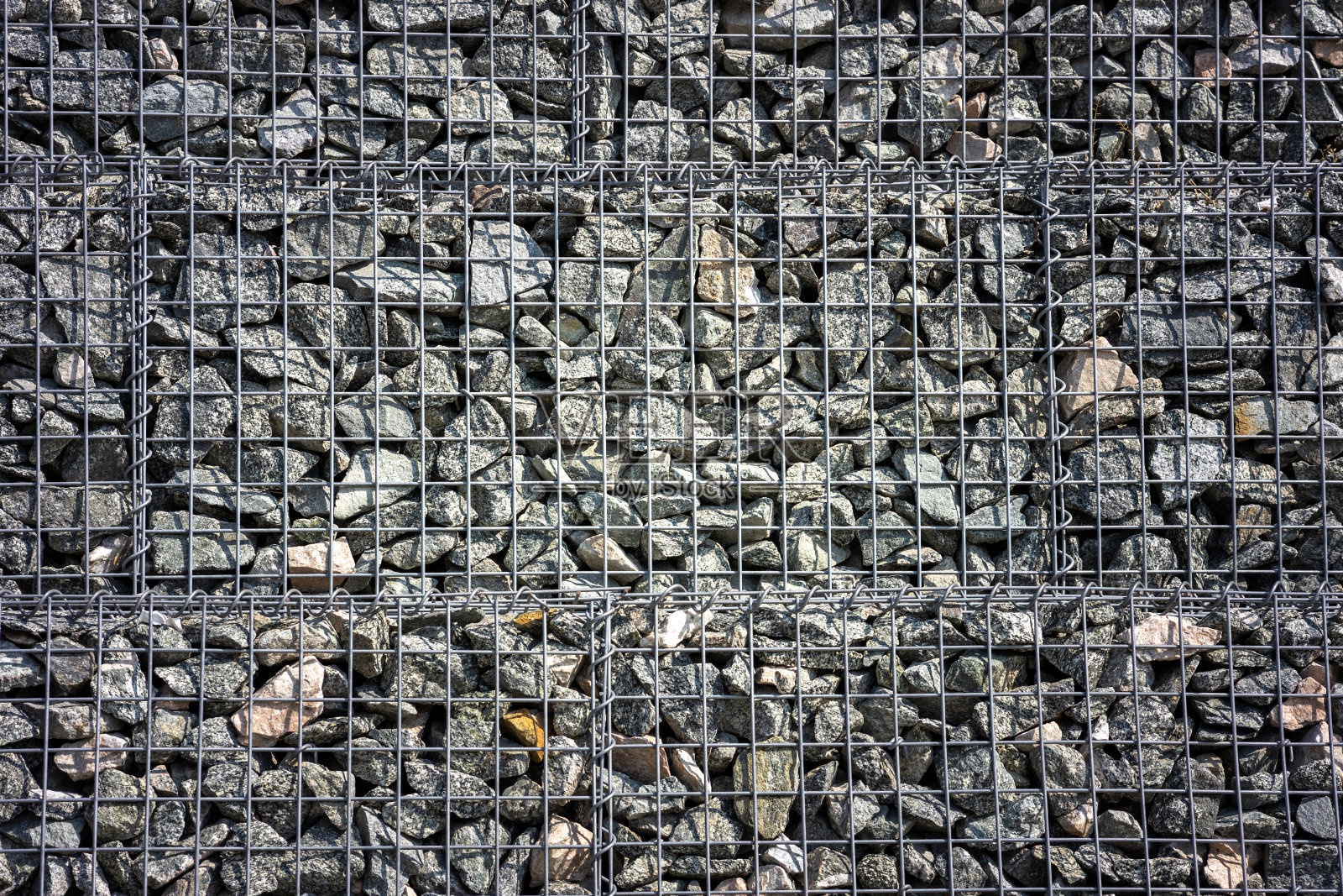 碎石下有石网，一堵碎石网夹着石块照片摄影图片