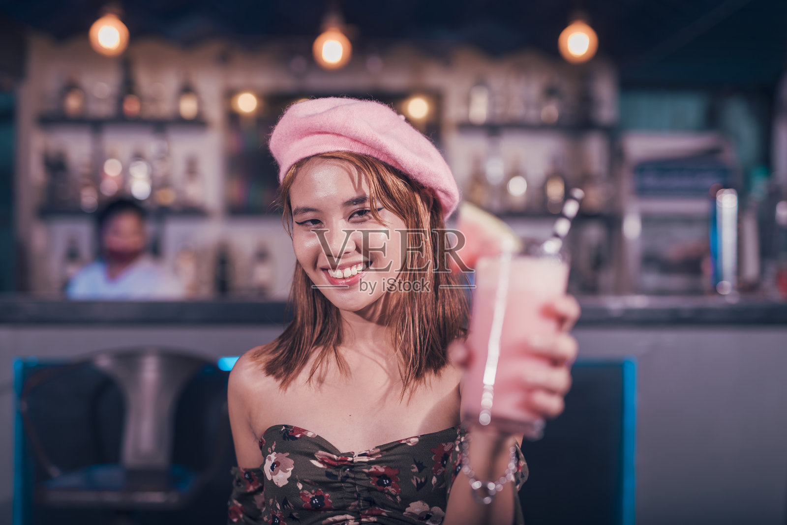 一个时尚的亚洲少女在酒吧庆祝她的18岁生日。喝一杯西瓜奶昔。照片摄影图片