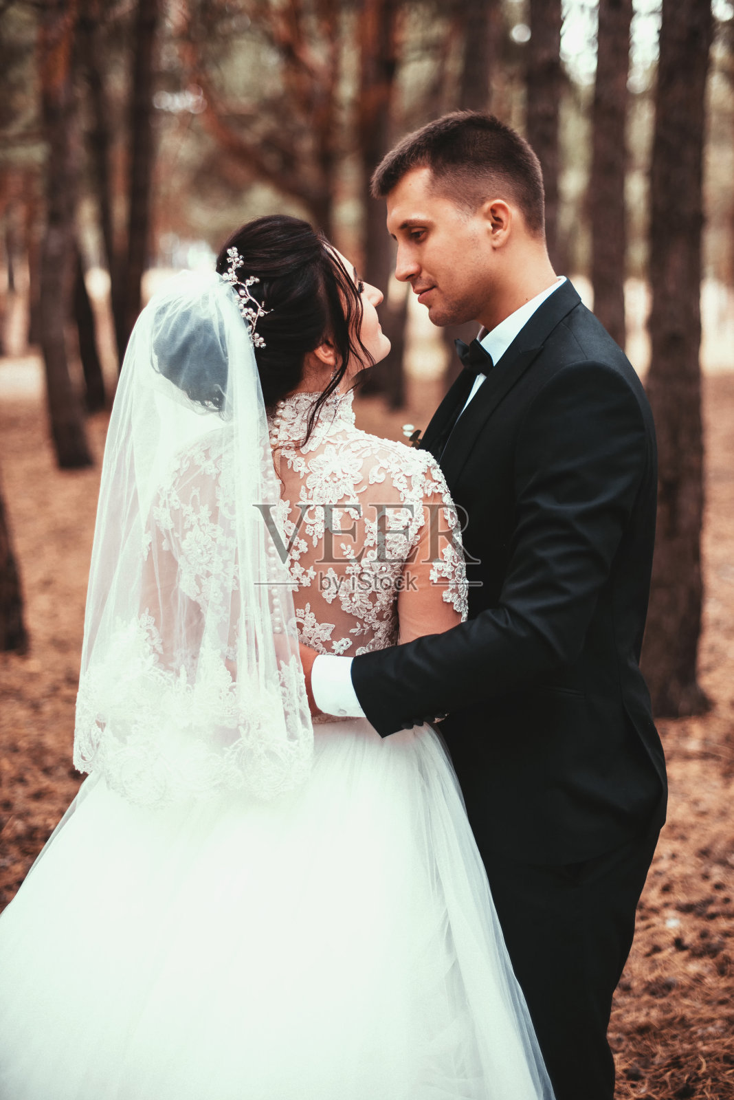 新婚夫妇在森林里互相看了一眼照片摄影图片