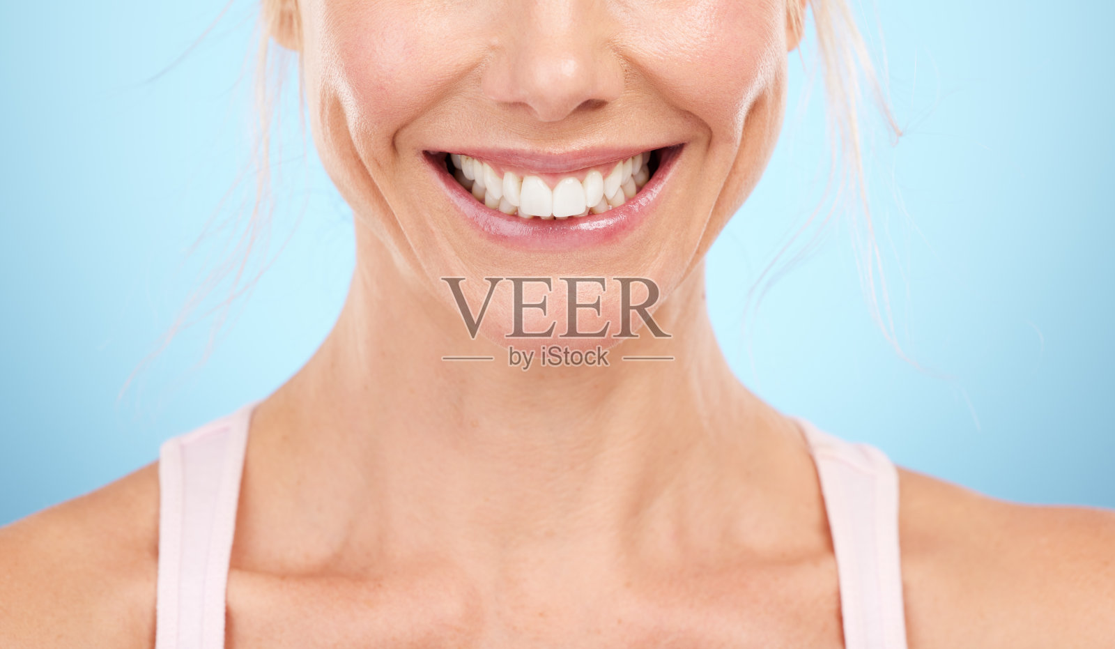 微笑，牙齿美白和女人的嘴在工作室，蓝色背景和面部健康。特写女模特，干净的牙齿和清新口气的笑脸，植牙和健康的美感照片摄影图片