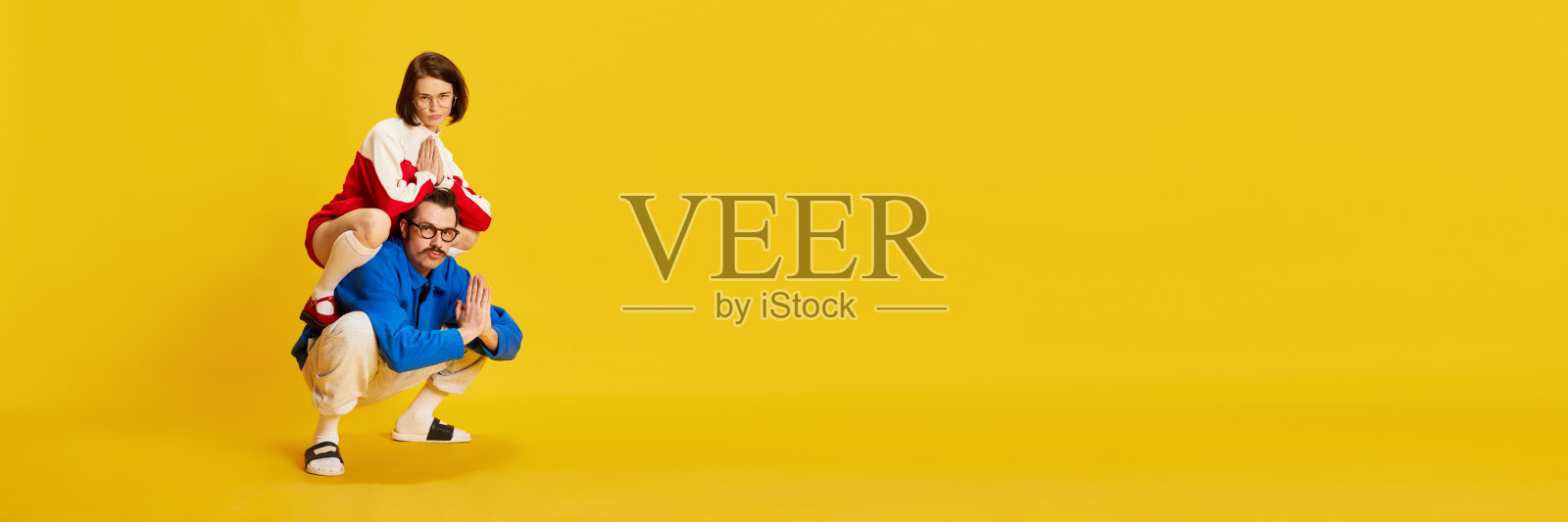 横幅上有一对有趣的夫妇，男人和美丽的女人穿着运动复古风格的衣服，看着黄色背景的相机做鬼脸。广告、文字的复制空间照片摄影图片