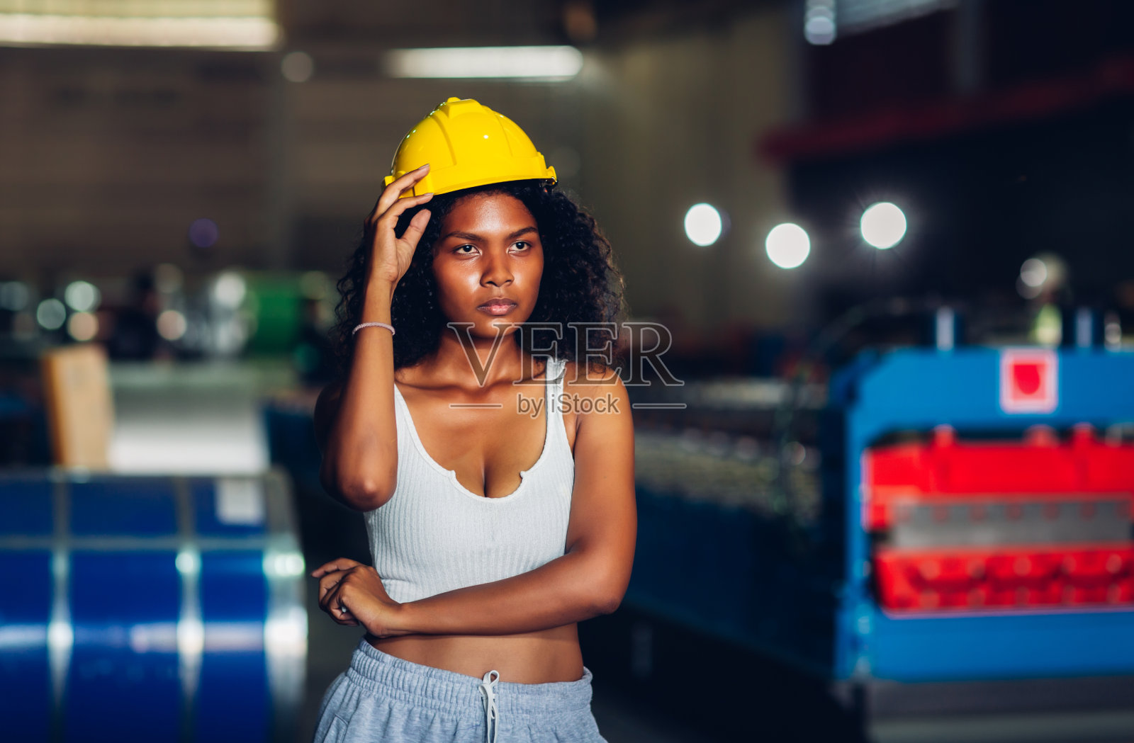 非裔美国女工站在工厂的工作场所。女工站在工厂车间自信地摆姿势照片摄影图片