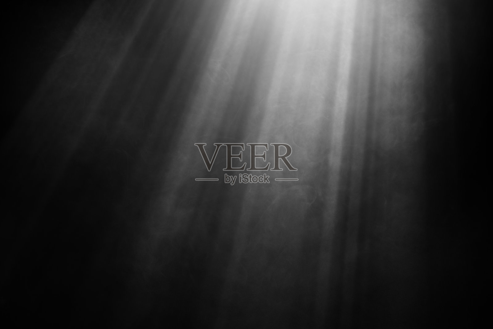 Light beams and smoke against black background照片摄影图片